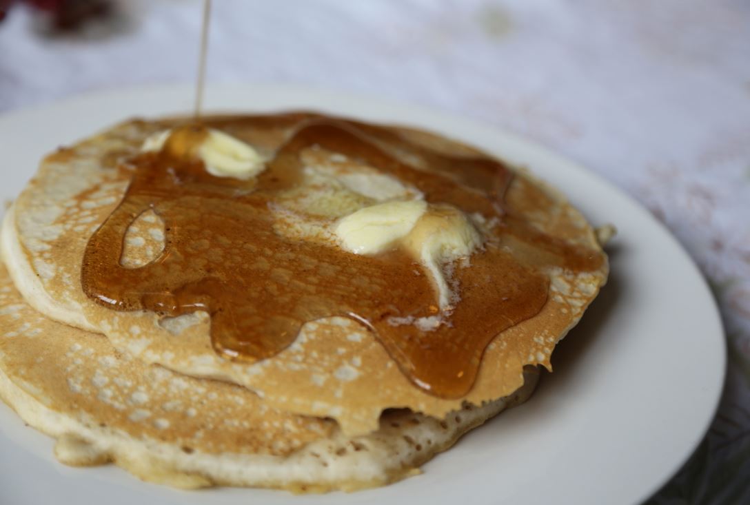 freshly made pancakes topped with melted butter and syrup